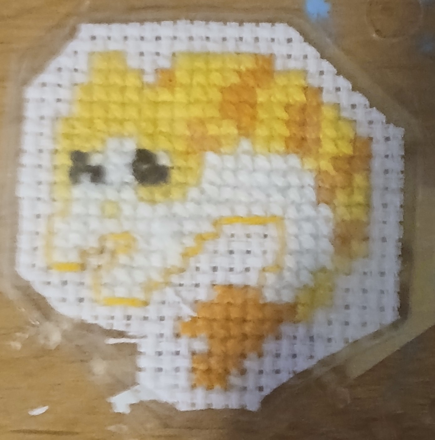 A cross stitch of a shrimp-cat