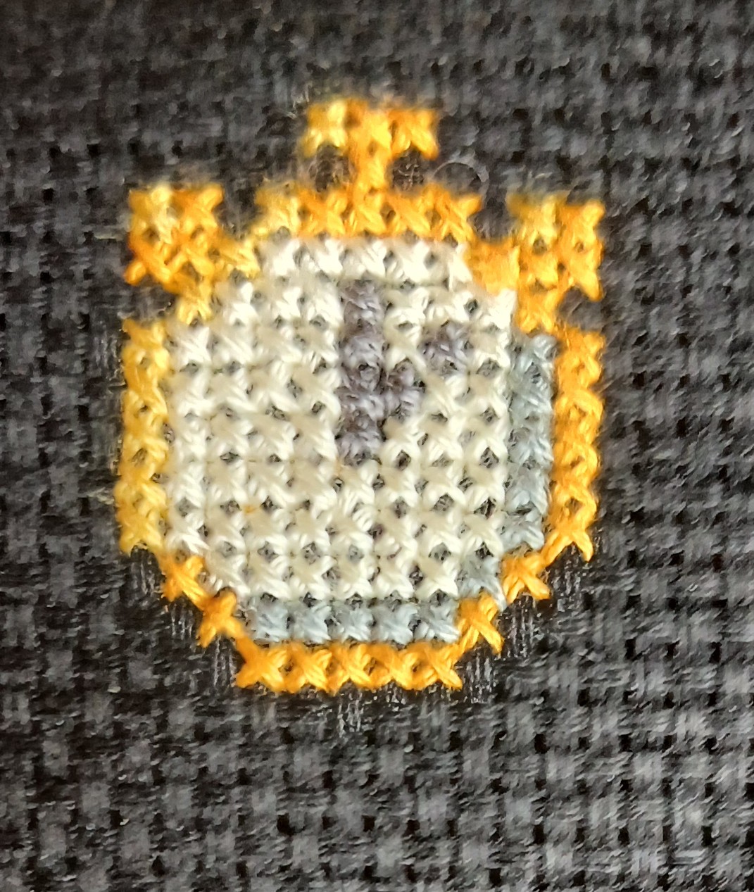 A cross stitch of a stopwatch